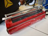 a red box with a black handle and a pair of scissors in it
