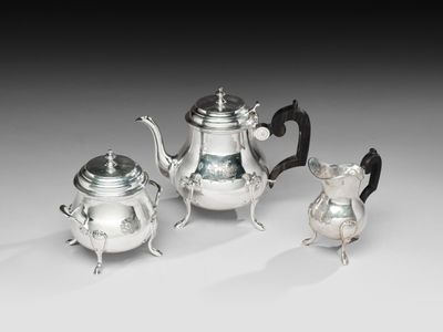 trois pièces en argent pour le thé et le café sur une table