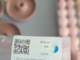 a person holding a bottle with a qr code on it