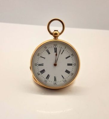 une montre de poche en or avec des chiffres romains sur le cadran