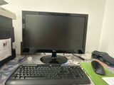 a computer monitor, keyboard and mouse on a desk