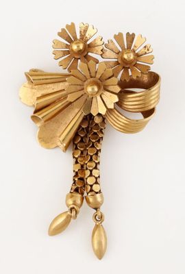 une image représentant une broche en or ornée de fleurs