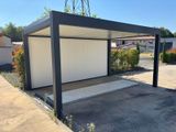 une image représentant un garage blanc avec un toit noir et une porte blanche