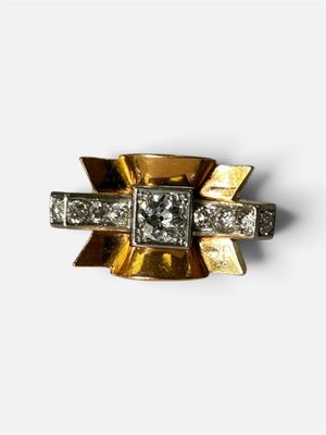 gros plan d'une bague en or et diamants sur une surface blanche