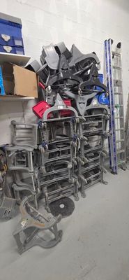 a lot of chairs that are stacked up in a room