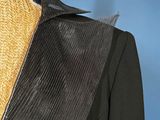 an image of a mannequin wearing a black jacket and gold necklace