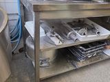 a kitchen with a large metal table with a lot of items on it