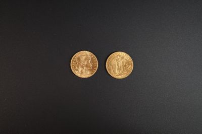 deux pièces d'or posées sur une surface noire