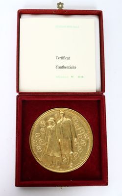 an image of a gold medal in a red box on a white surface