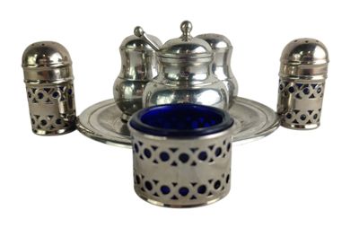 a silver tea set with a blue glass in it
