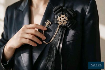 une femme vêtue d'une veste noire, tenant une broche en forme d'étoile