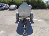 a trailer with a tank attached to it in a parking lot