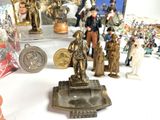 many figurines on a table with a lot of other figurines in the background