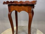 une vieille table en bois avec un plateau en marbre, posée sur un piédestal