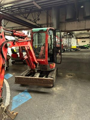 une pelleteuse rouge garée dans un garage