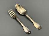 deux fourchettes et une cuillère posées sur une table devant un fond gris