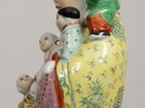 a figurine of a woman and two children sitting on a rock