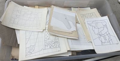 a lot of drawings in a box on the ground