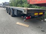 un camion à plateau garé sur le bord de la route