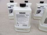 four bottles of karcher cleaner sitting on top of a table