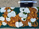a green and gold scarf with white flowers on it