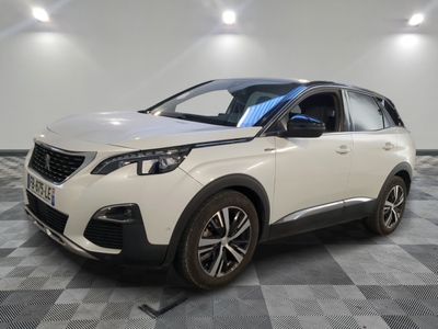 une voiture blanche garée sur un sol en damier dans un garage
