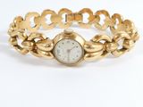 an image of a woman ' s gold bracelet watch with a white dial
