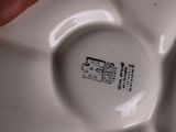 a person holding a white plate with black writing on it
