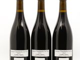 trois bouteilles de vin posées les unes à côté des autres sur une surface blanche