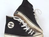 une paire de baskets noires et blanches portant le logo de Chanel