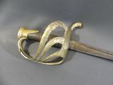 a sword with a gold handle on a gray surface