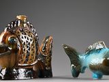 two figurines of a fish and a fish on a table