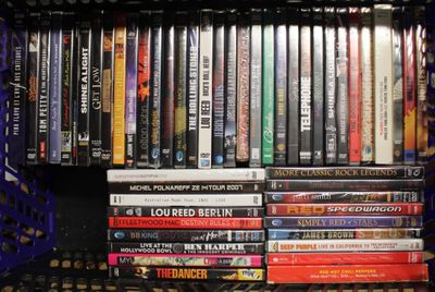 beaucoup de DVD sur une étagère dans la pièce