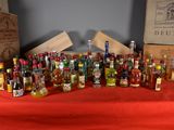 many bottles of alcohol sitting on a table with a red cloth