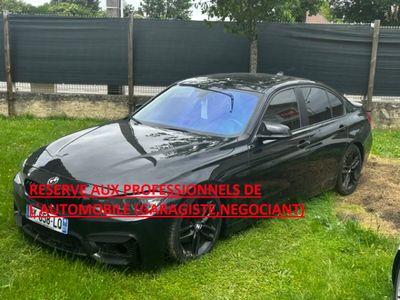 La voiture noire est garée dans l'herbe, près d'une clôture.