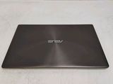 the back of a laptop computer sitting on top of a white surface