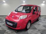 the small red van is parked in a large room