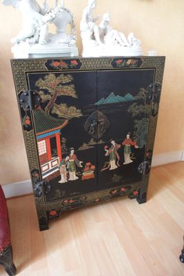 un meuble noir orné d'un tableau, dans un coin de la pièce