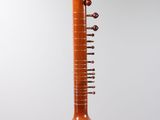 an indian musical instrument hanging from a string on a gray background