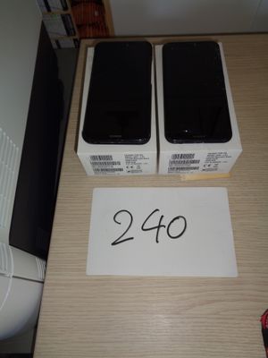 two black phones sitting on top of a wooden table