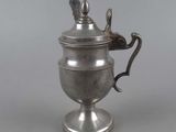 an antique silver plated teapot with a handle on a stand
