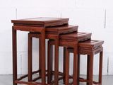 un ensemble de trois tables gigognes en bois posées sur un sol en ciment