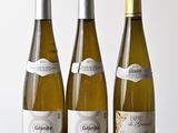 trois bouteilles de vin posées sur une table en bois