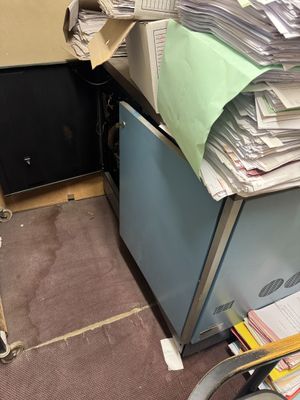 a pile of papers sitting on top of a filing cabinet