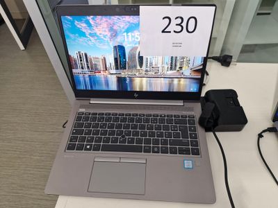 un ordinateur portable posé sur un bureau, avec une horloge à l'écran