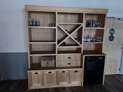 une armoire en bois avec un casier à bouteilles dans un coin