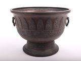 a large metal vase that is sitting on a white surface