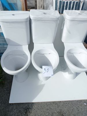 three toilets sitting on a white table outside