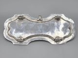an antique silver plate with a decorative design on it