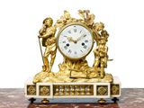 une horloge en or ornée d'anges, posée sur une table